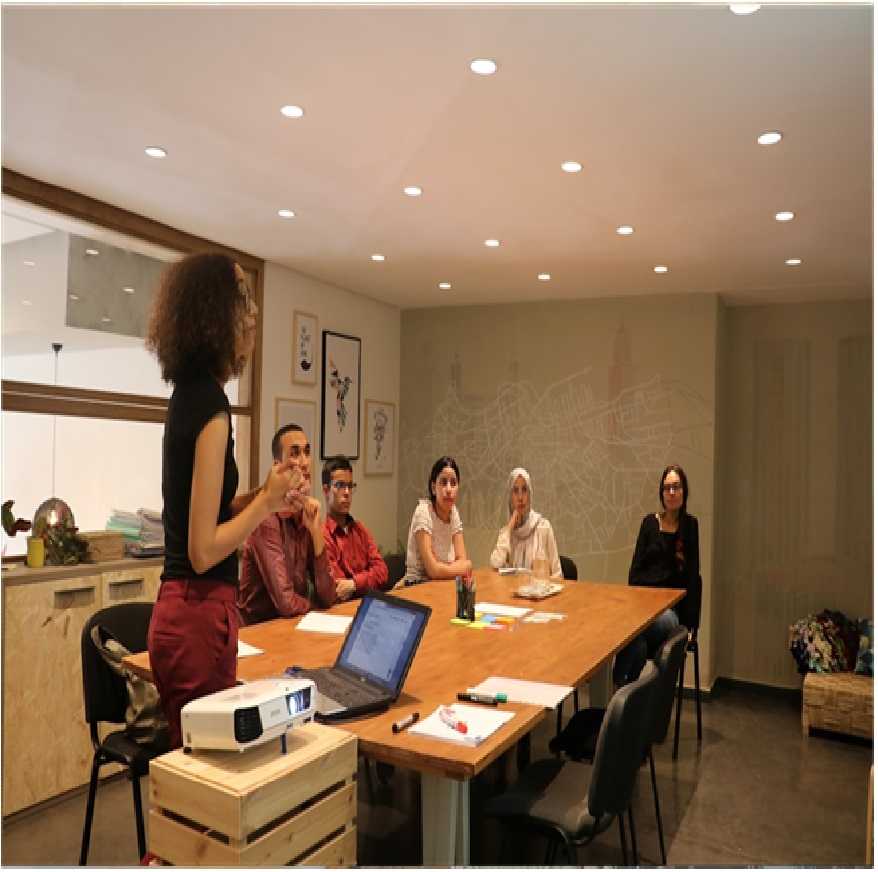  A woman stands before a group, explaining the concept of knowledge management systems during her presentation
